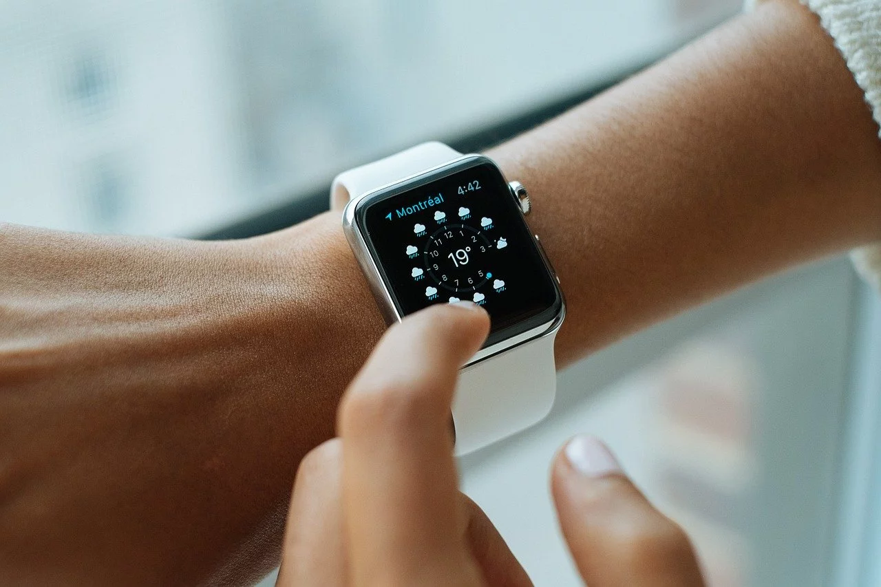 A black man has weared a smart watch on his right hand and he is pressing button with his left hand