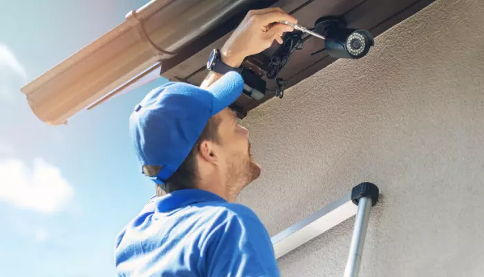 a person is installing security camera outside of the house