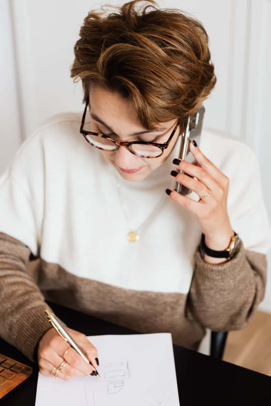 focused interior decorator in glasses having phone conversation with client - eyewear