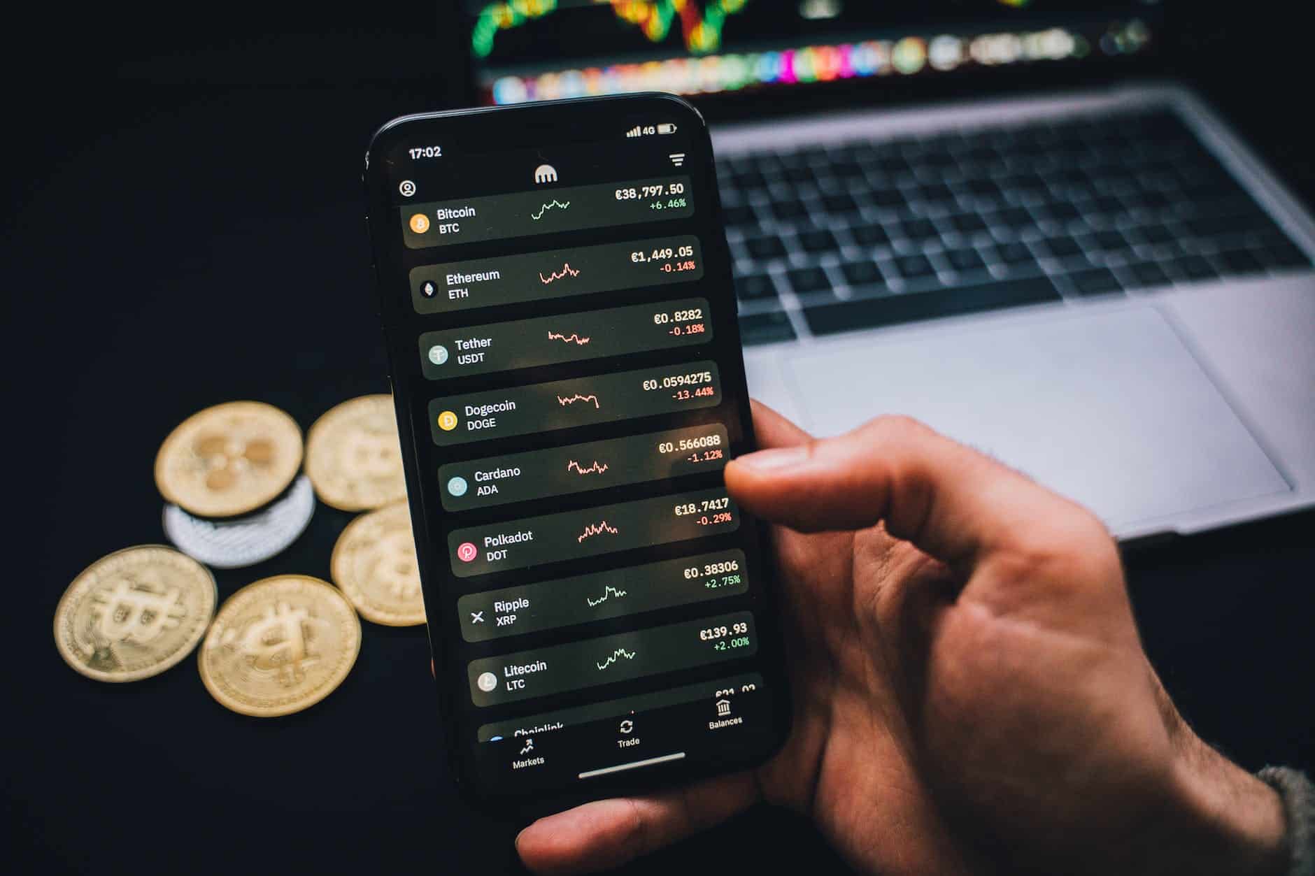 a person holding a smartphone with trading graphs - bitcoin scams